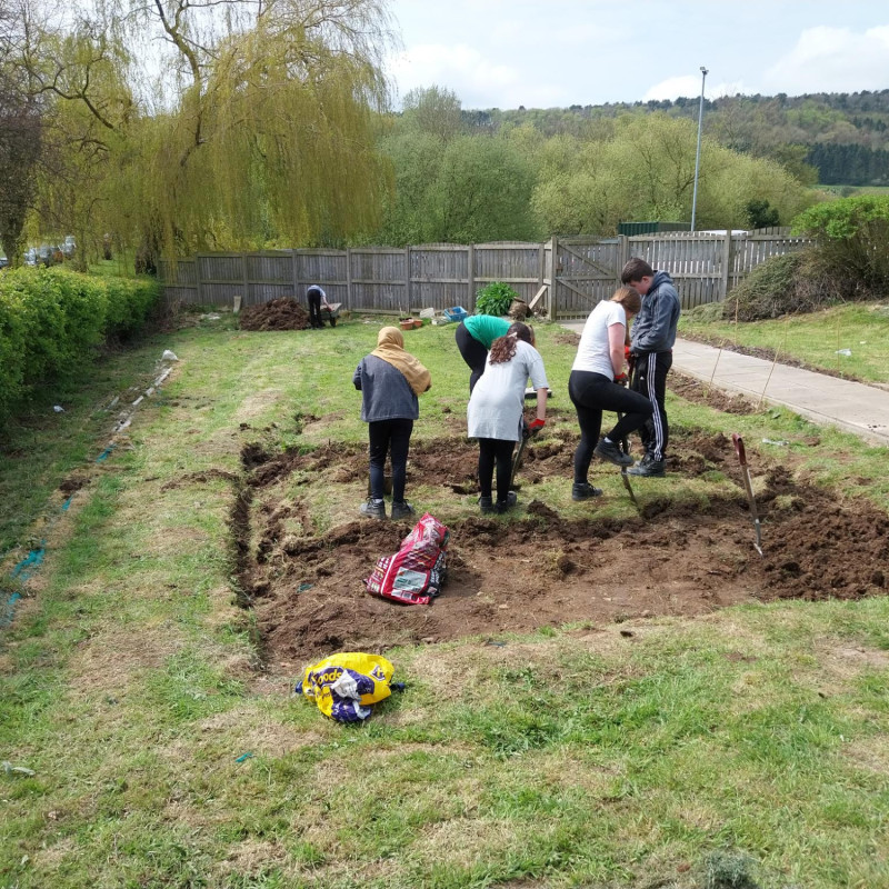 A group of students digging out a patch of grass