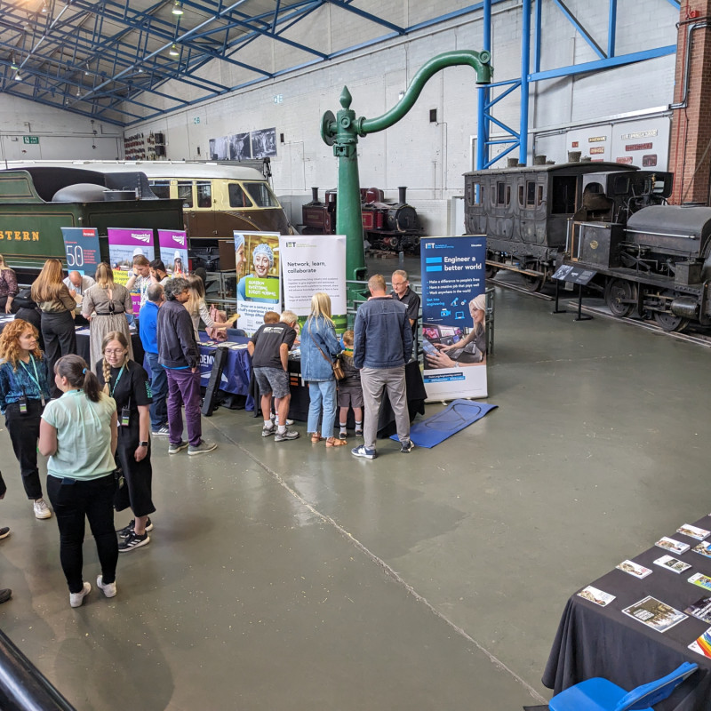 View of employer stands in the Great Hall of the National Railway Museum, with trains in the background.